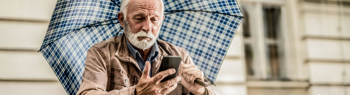 Older man using a Doro smartphone outdoors